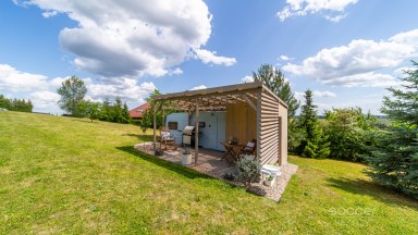 Příjemná venkovská zahrada s rekreačním karavanem a terasou.